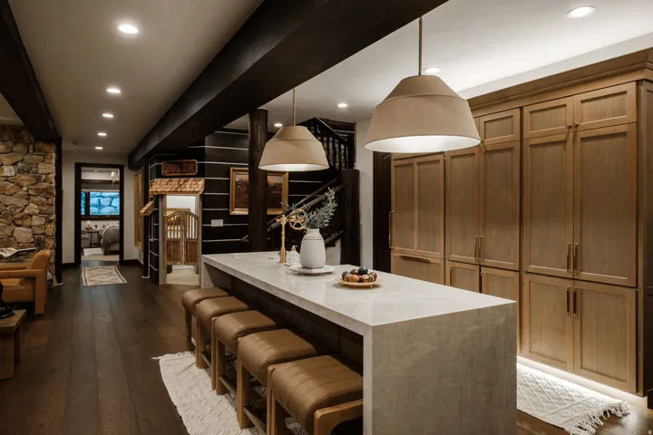 Kitchen island featuring a light-toned countertop, pendant lighting, and integrated seating