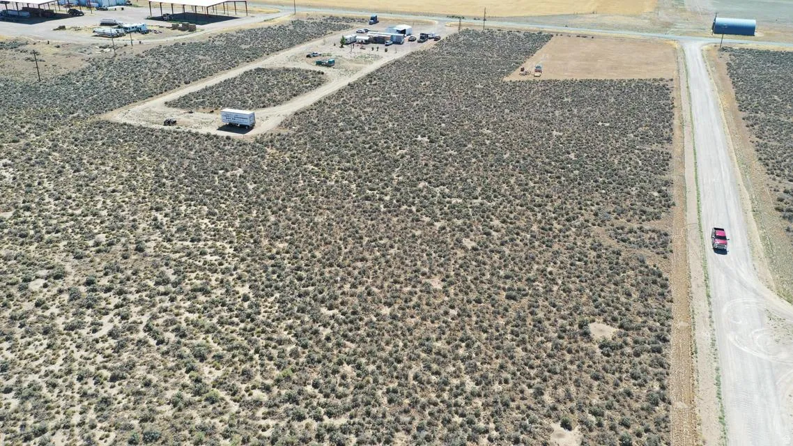 Expansive undeveloped land featuring natural desert vegetation, a visible dirt road, and clear open space