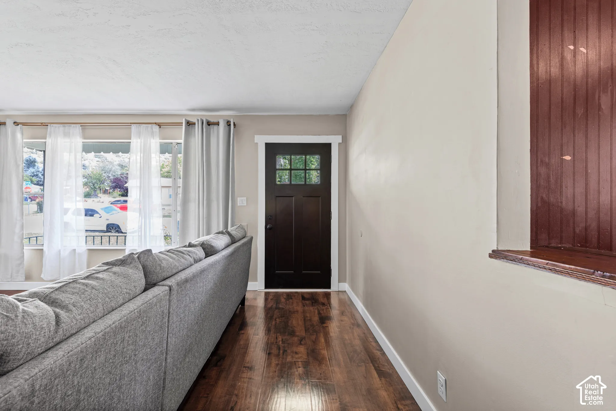 Entry area featuring a dark wood-finish door with glass inserts, wood-finish flooring, and light-toned walls