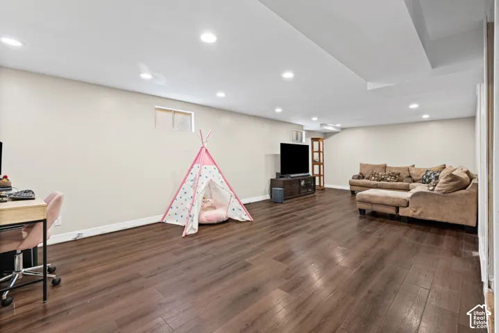 Spacious room featuring wood-finish flooring, recessed lighting, and neutral wall tones
