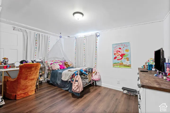 Spacious room featuring wood-finish flooring, white walls, and a recessed ceiling light fixture