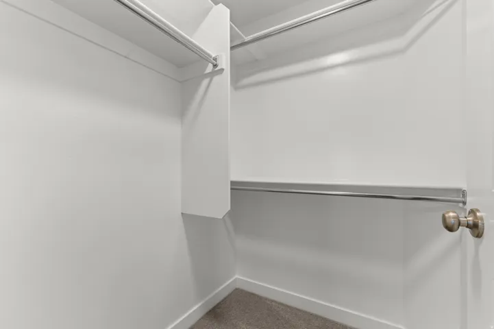 White closet interior with dual chrome hanging rods and white shelving