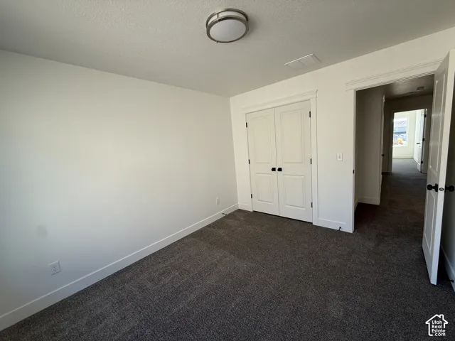 Neutral-toned carpeting, white walls, and a flush-mount ceiling fixture
