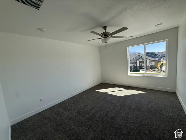 Carpeted room featuring a ceiling fan with integrated lighting, recessed lighting, and a large window with a distant mountain range