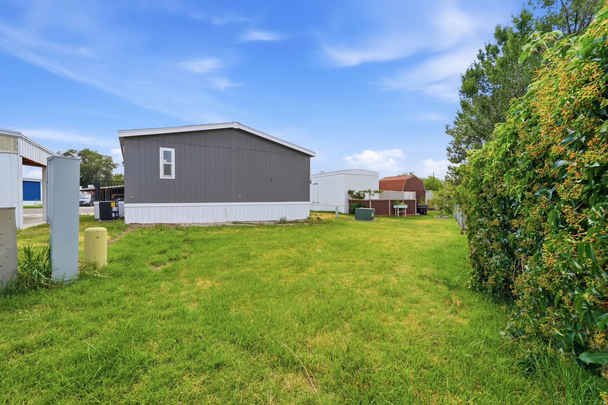 Expansive green lawn bordering a dark gray exterior with a white trim