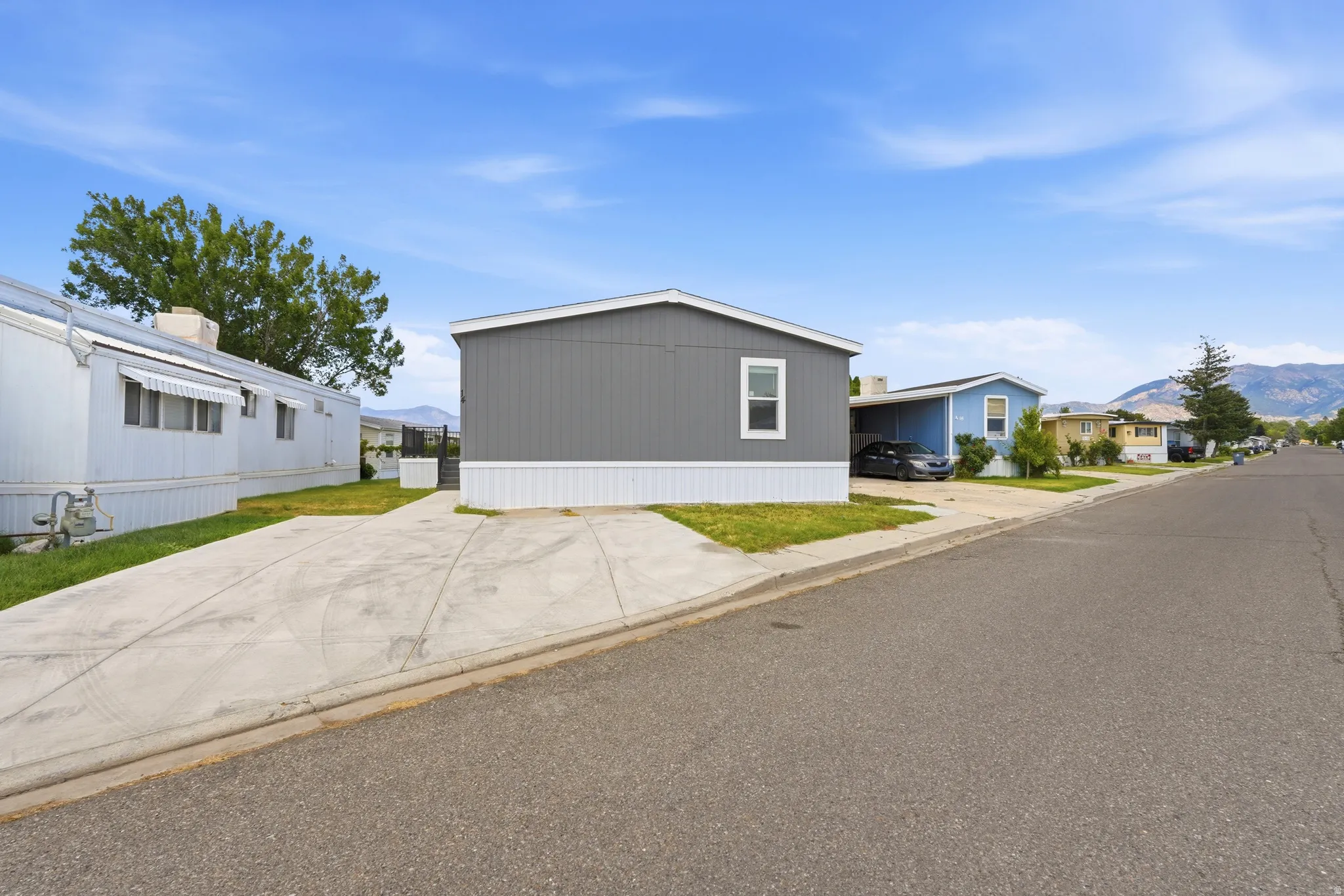 Contemporary manufactured home featuring gray horizontal siding and white trim