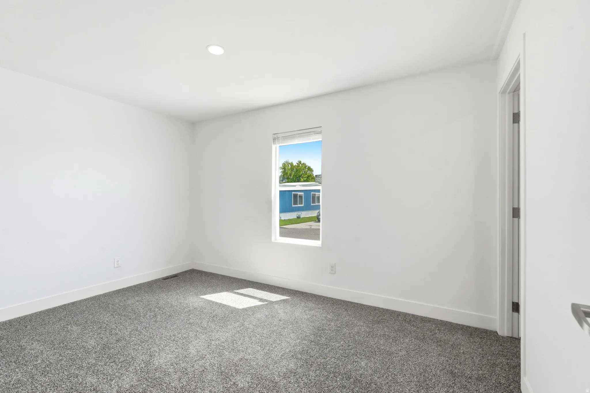 Room featuring neutral paint, gray carpeting, a single window, recessed lighting, and white baseboards