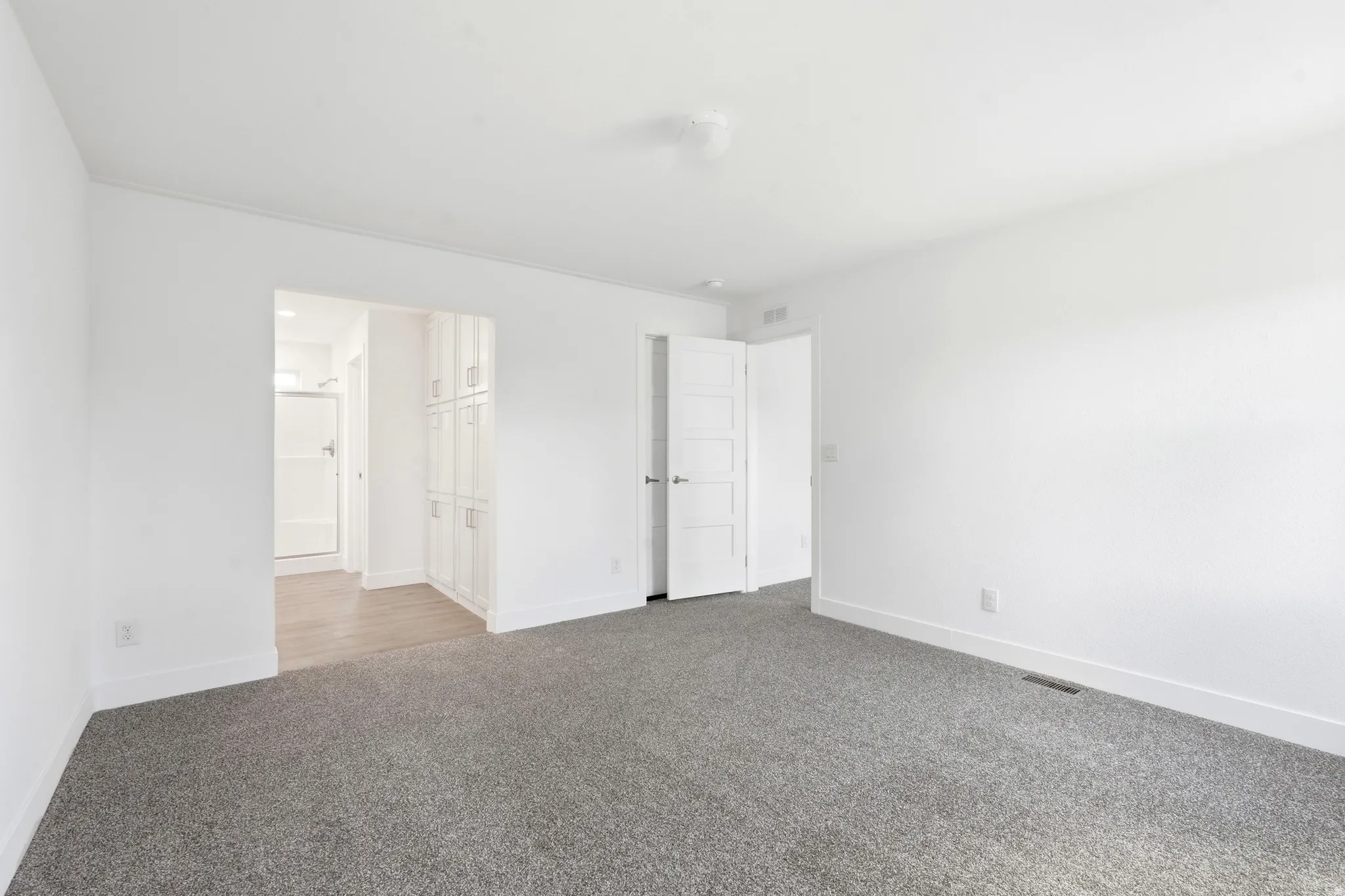 Spacious room with gray carpet flooring and white walls