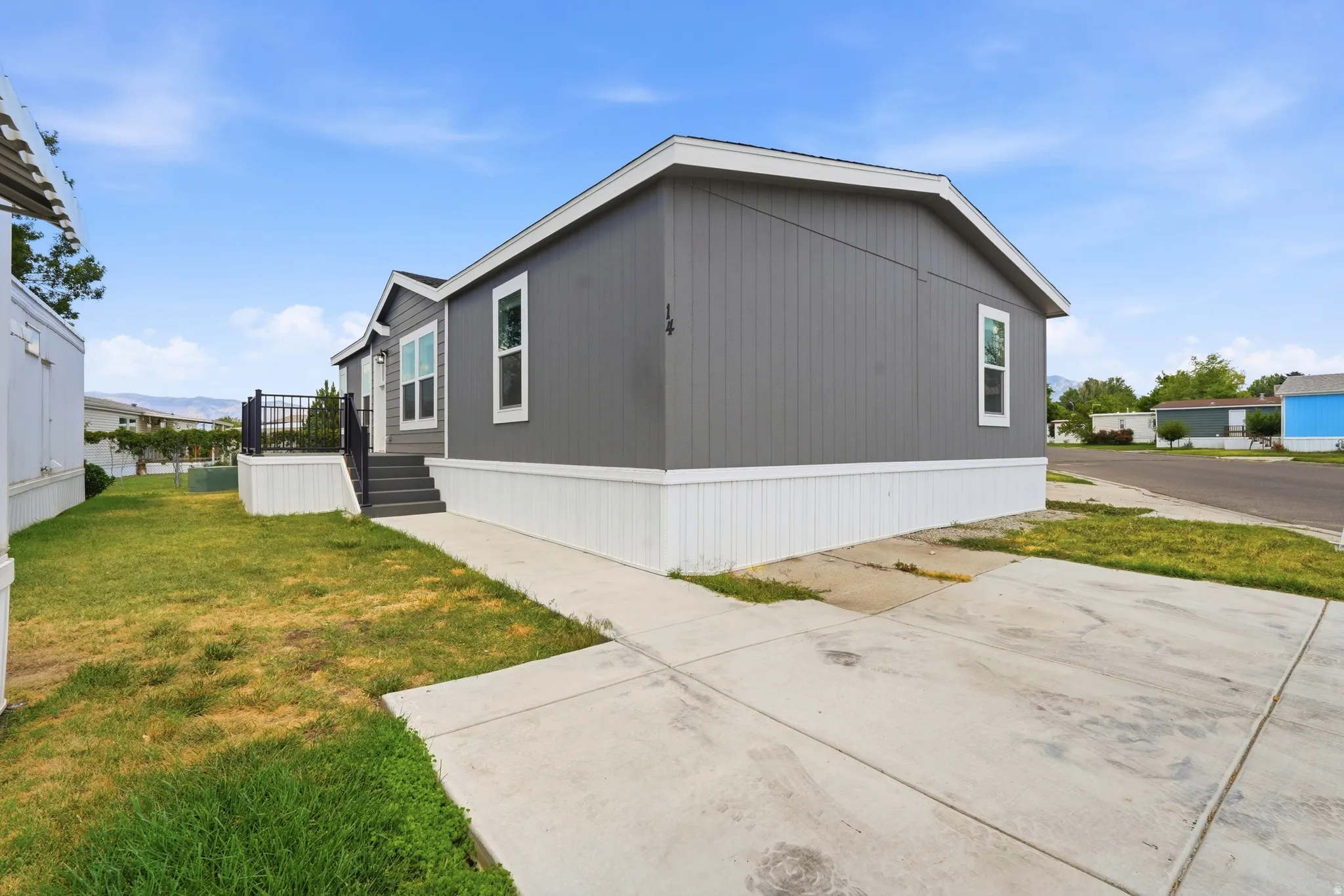 Contemporary gray siding exterior with white trim and a white foundation skirt