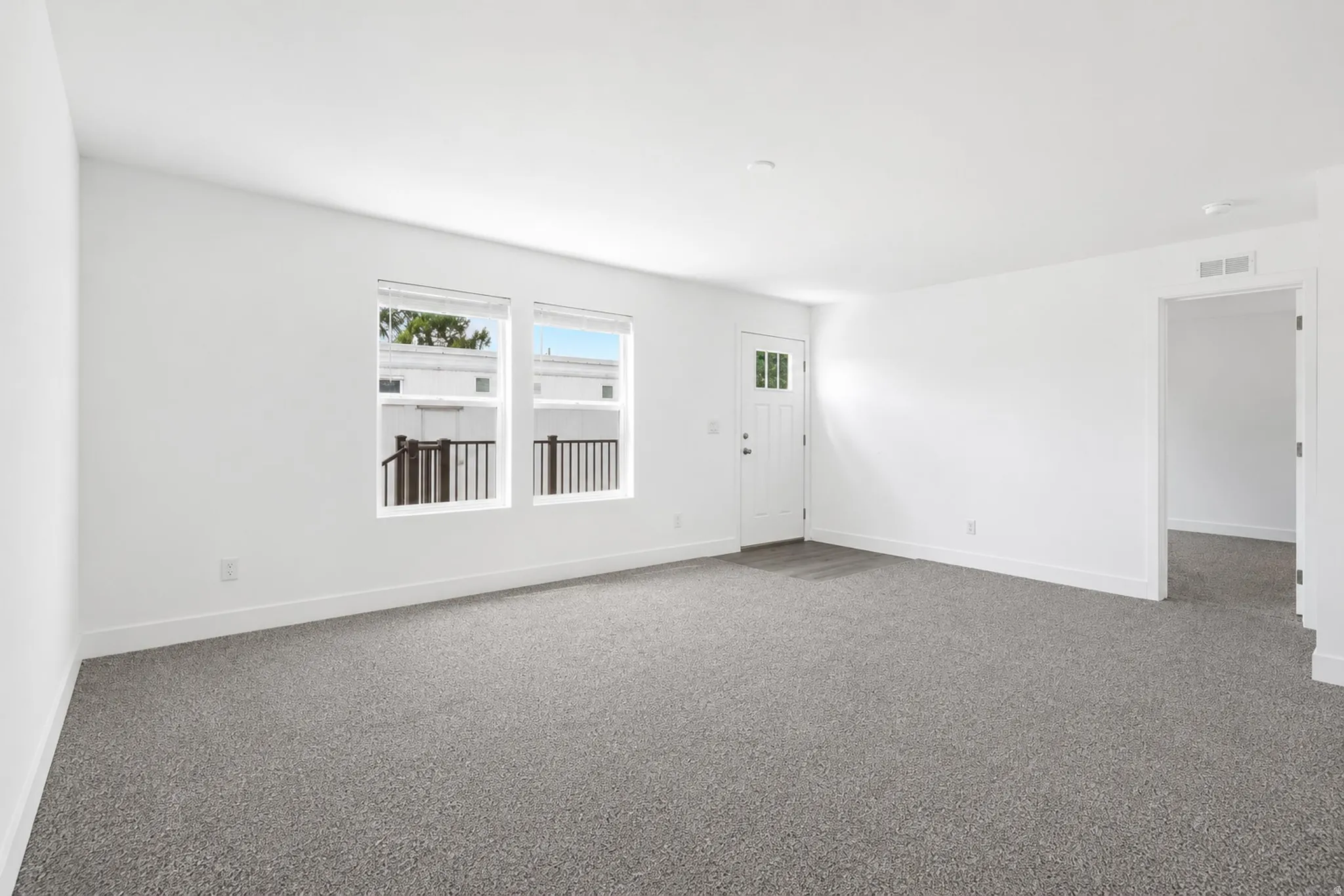 Spacious room featuring neutral carpeting and white wall finishes