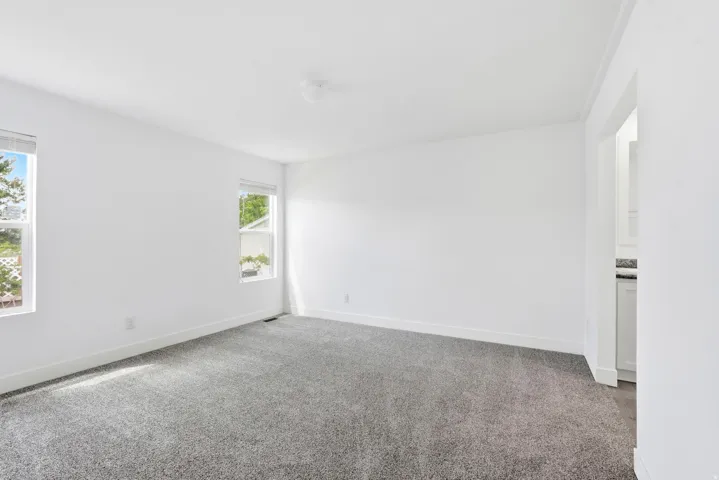 Spacious room featuring neutral carpeting and bright white walls