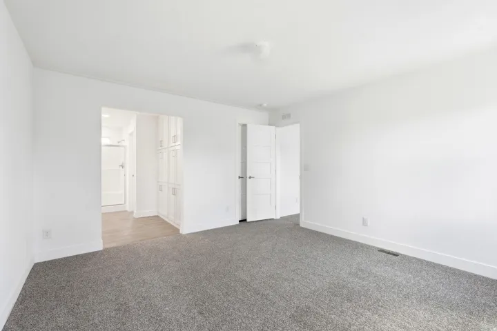 Spacious room with gray carpet flooring and white walls