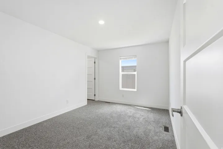 Bedroom featuring light gray carpeting, white walls, a recessed ceiling light, and a single window