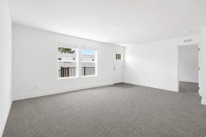 Spacious room featuring neutral carpeting and white wall finishes