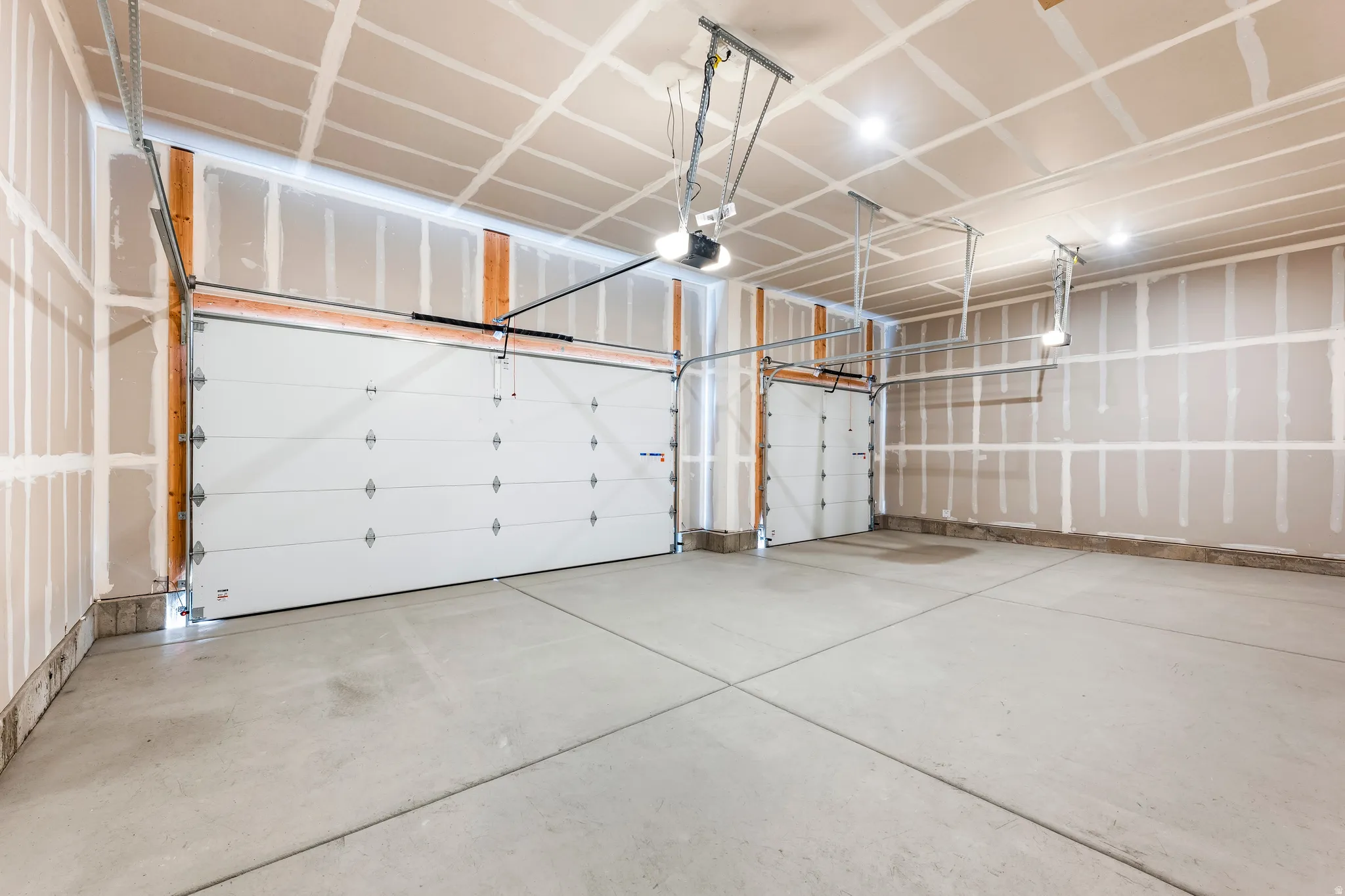Two white sectional garage doors with exposed framing