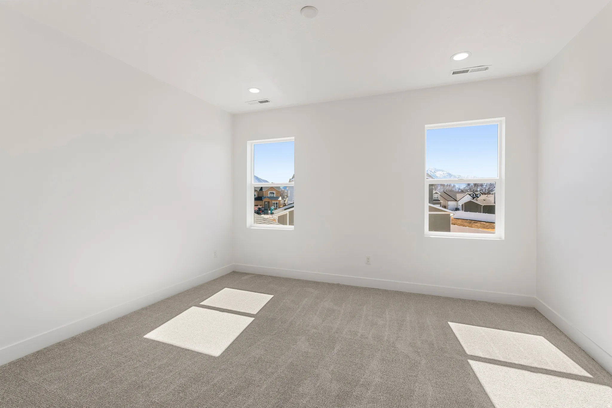 Room featuring plush carpeting, dual windows, recessed lighting, and crisp white walls