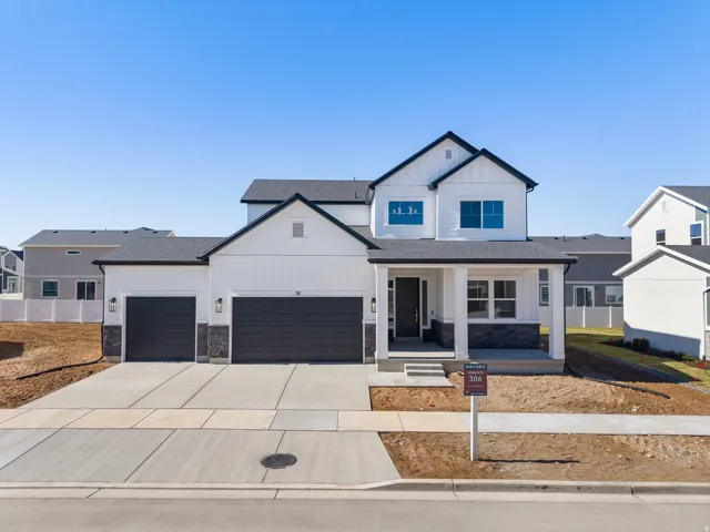 Contemporary two-story residence featuring white siding, dark trim, and a covered front porch with stone accents