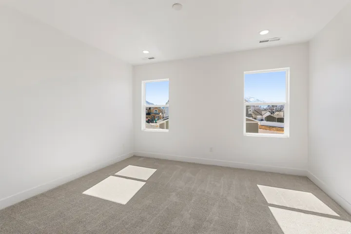 Room featuring plush carpeting, dual windows, recessed lighting, and crisp white walls