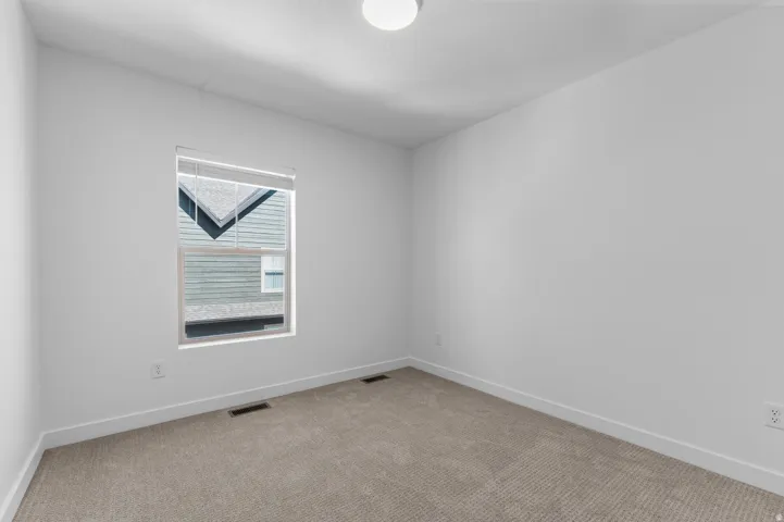 Neutral tone wall finishes, window with blinds, overhead lighting fixture, and carpet flooring