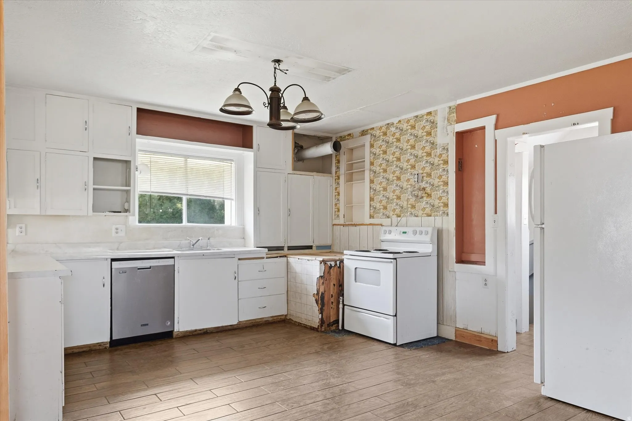 Kitchen featuring white cabinetry, a double-basin sink, and wood-finish flooring