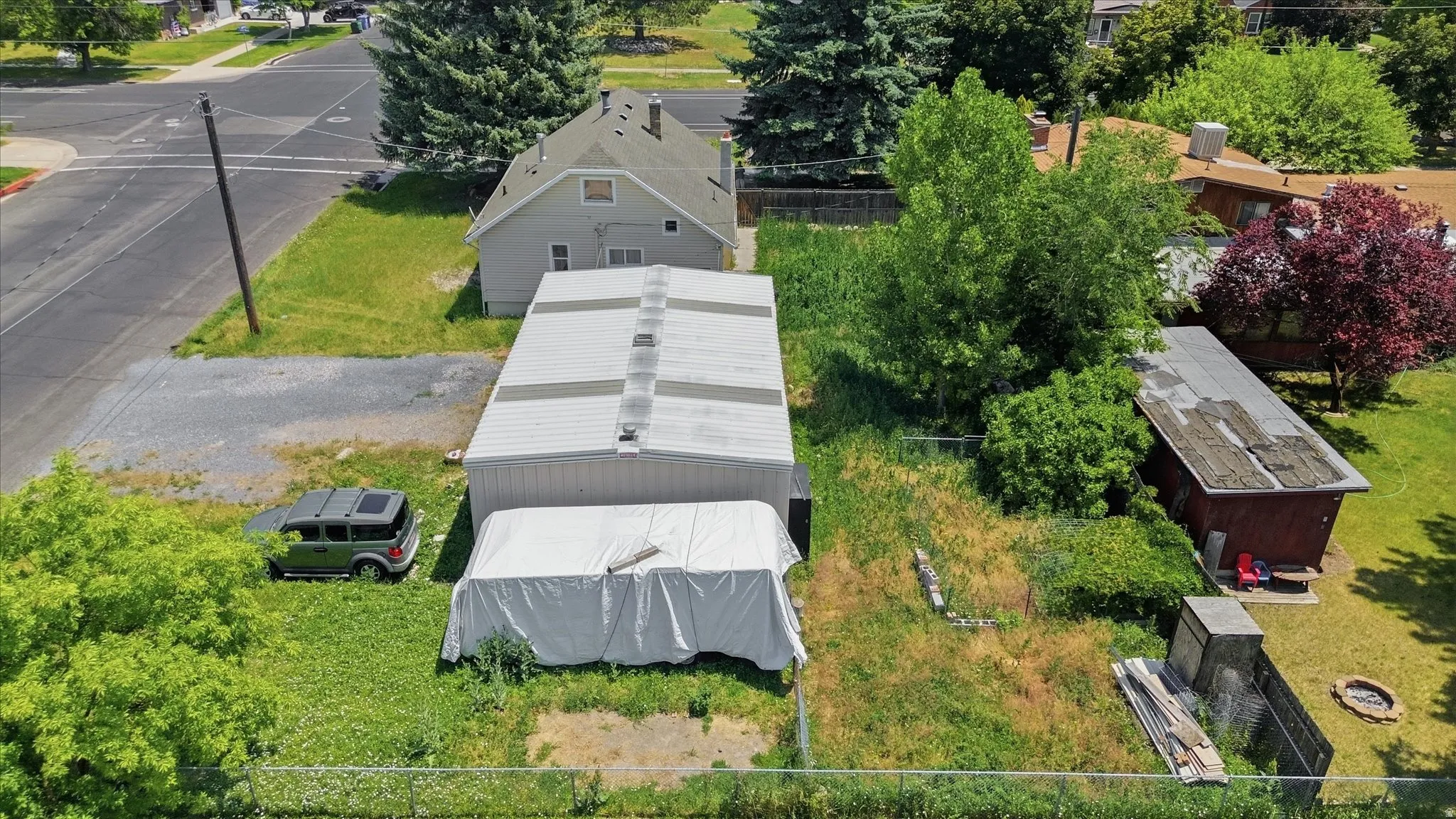 Expansive lot featuring a large outbuilding with a metal roof and a separate smaller shed