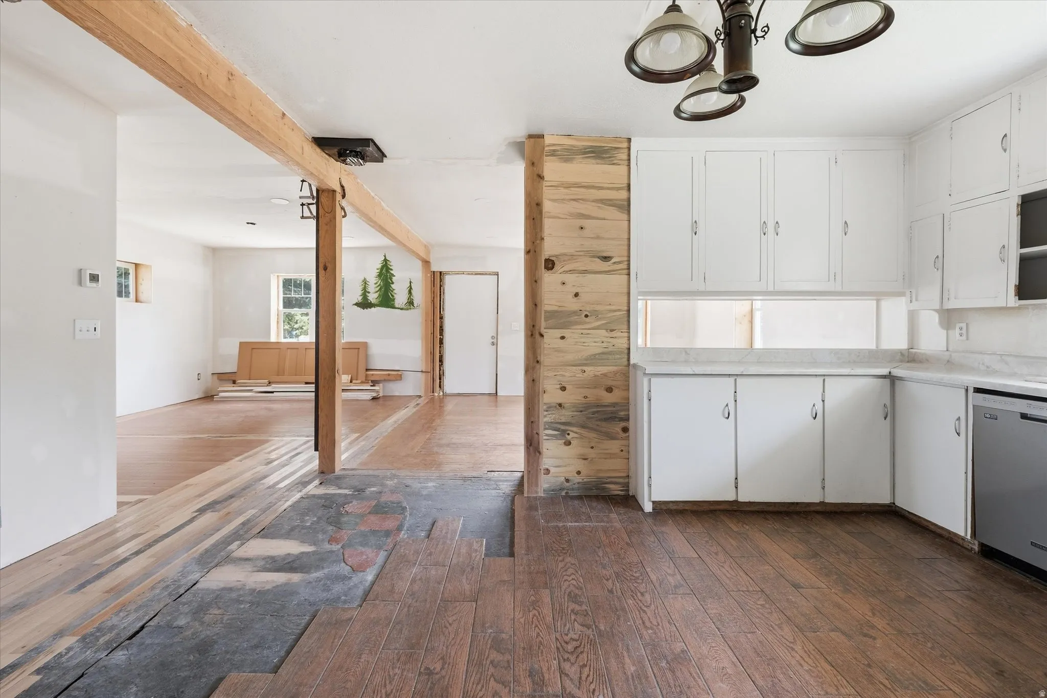 Kitchen space featuring white cabinetry, light-toned countertops, and dark wood-finish flooring