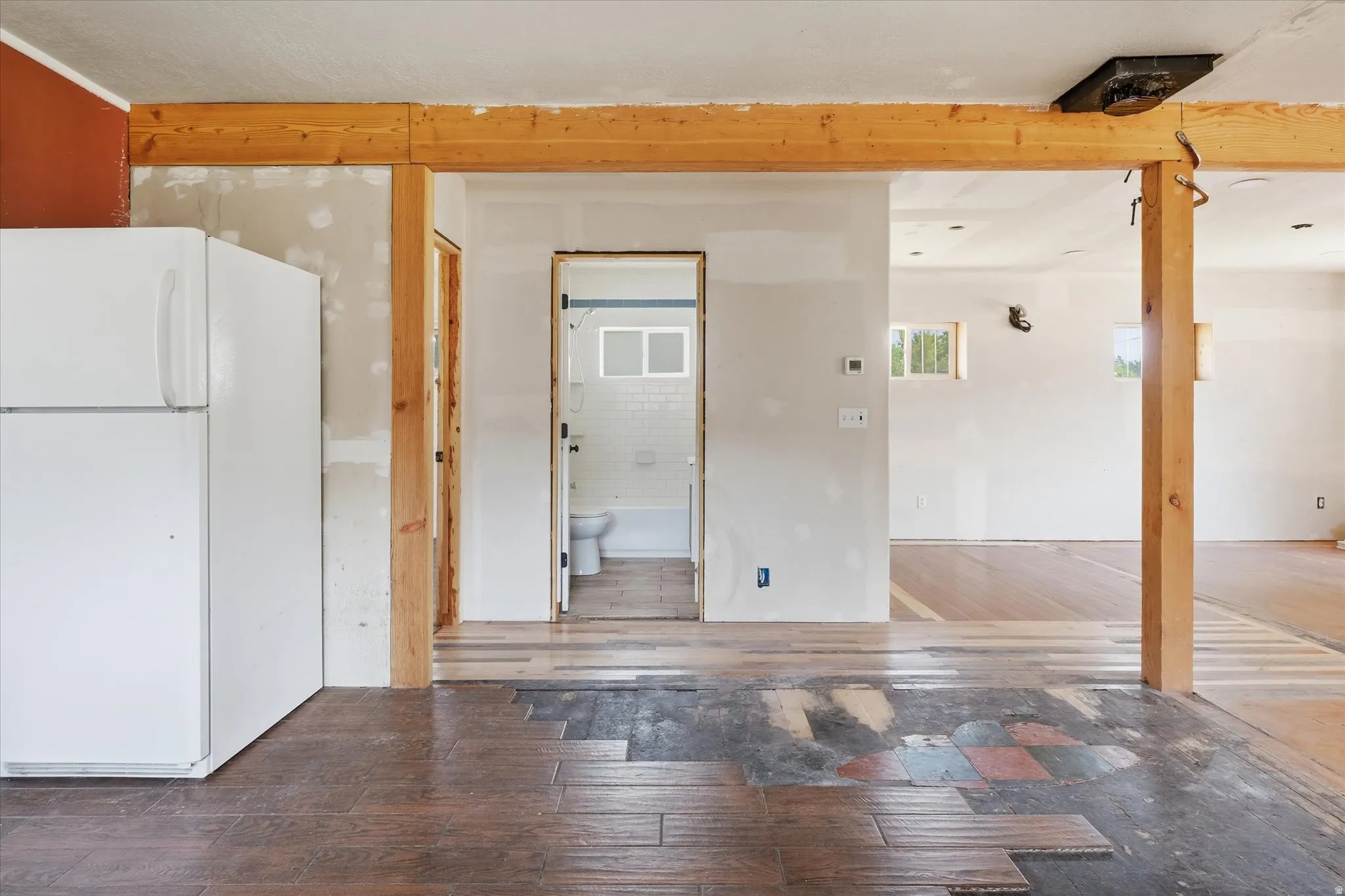 Interior featuring visible structural beams, wood-finish flooring, and recessed lighting