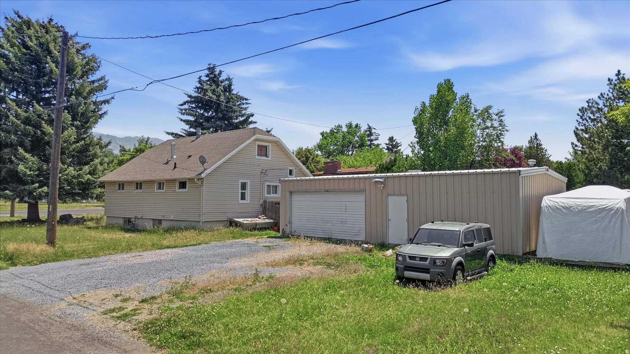 Two-story residence with light-colored siding and an attached garage structure
