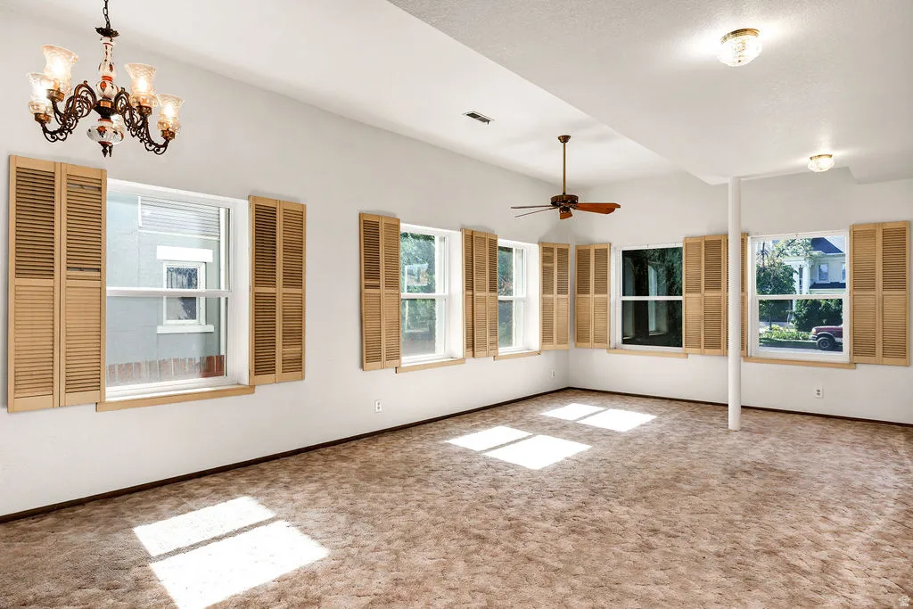 Spacious room with multiple windows featuring wood-tone plantation shutters