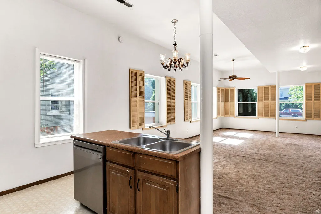 Kitchenette area featuring a stainless steel dishwasher, double basin sink, and wood cabinetry