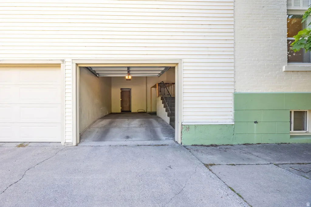 Two-car garage featuring a roll-up door, interior lighting, and a concrete driveway