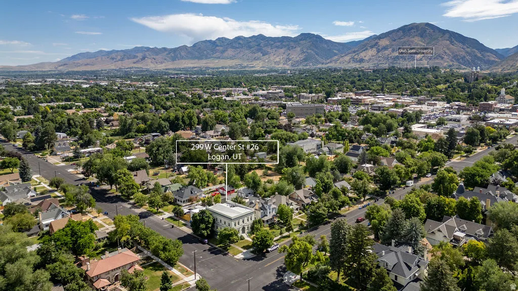Aerial perspective showcasing a community setting with extensive tree canopies and mountainous terrain