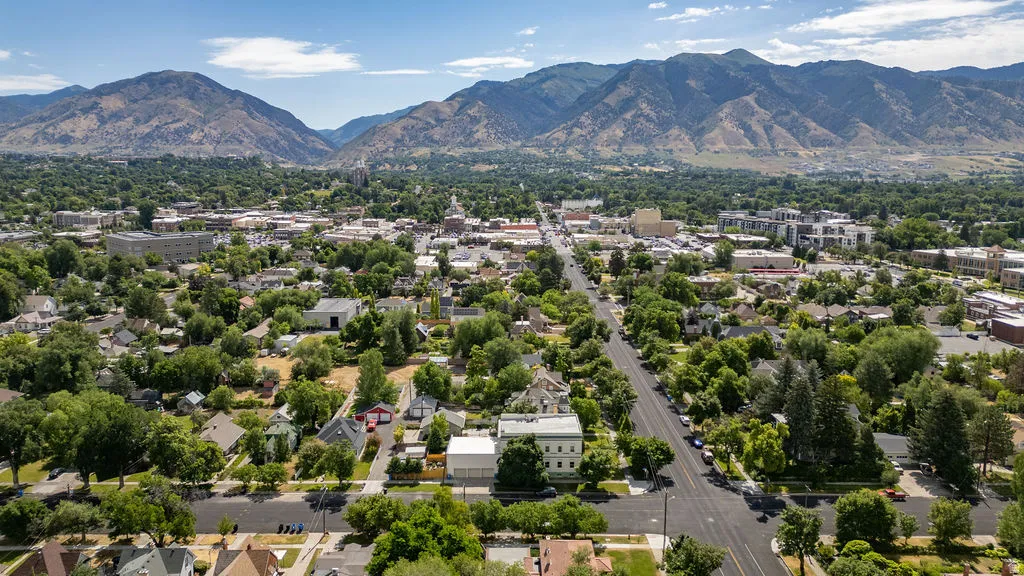 Aerial perspective showcasing a verdant landscape with extensive tree canopy, residential streets, and commercial buildings