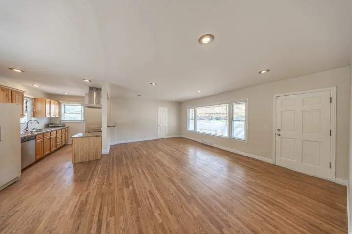 Open-concept living area with wood-finish flooring extending into the kitchen