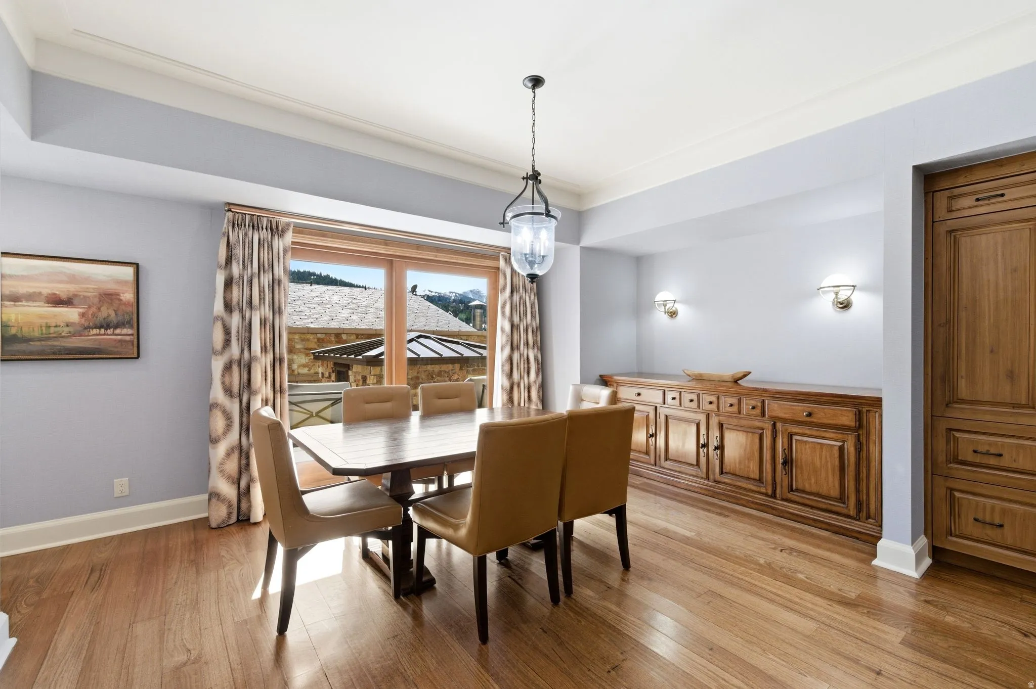 Dining area featuring wood-finish flooring, a tray ceiling, and a large window