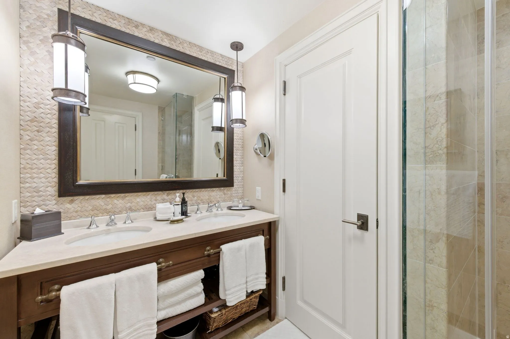 Bathroom featuring a double vanity with stone countertop, dual undermount sinks, and dark wood cabinetry