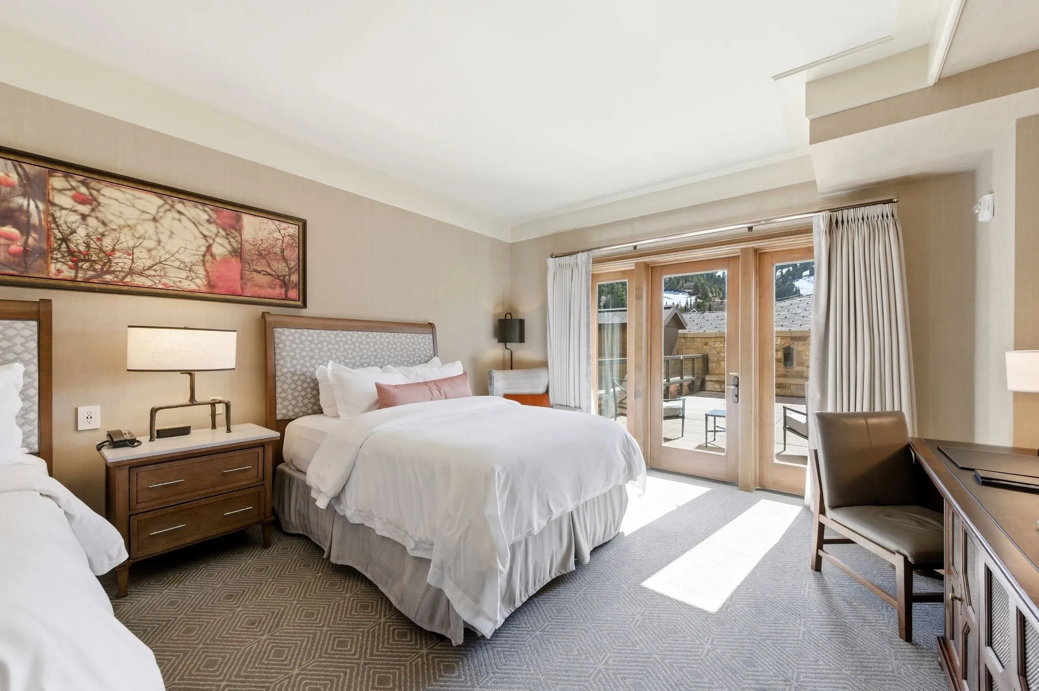 Spacious room featuring light-colored walls and a patterned carpet