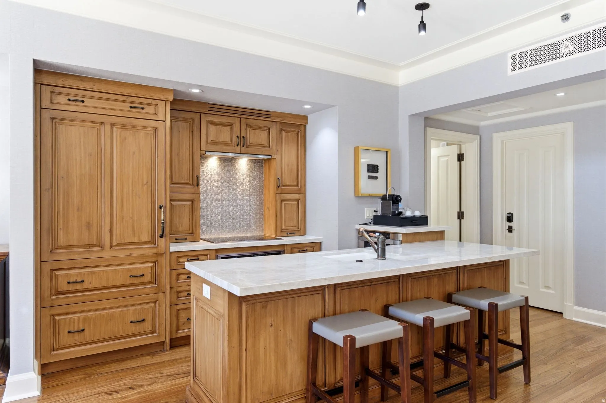 Wood-finish cabinetry and island with light-toned countertop