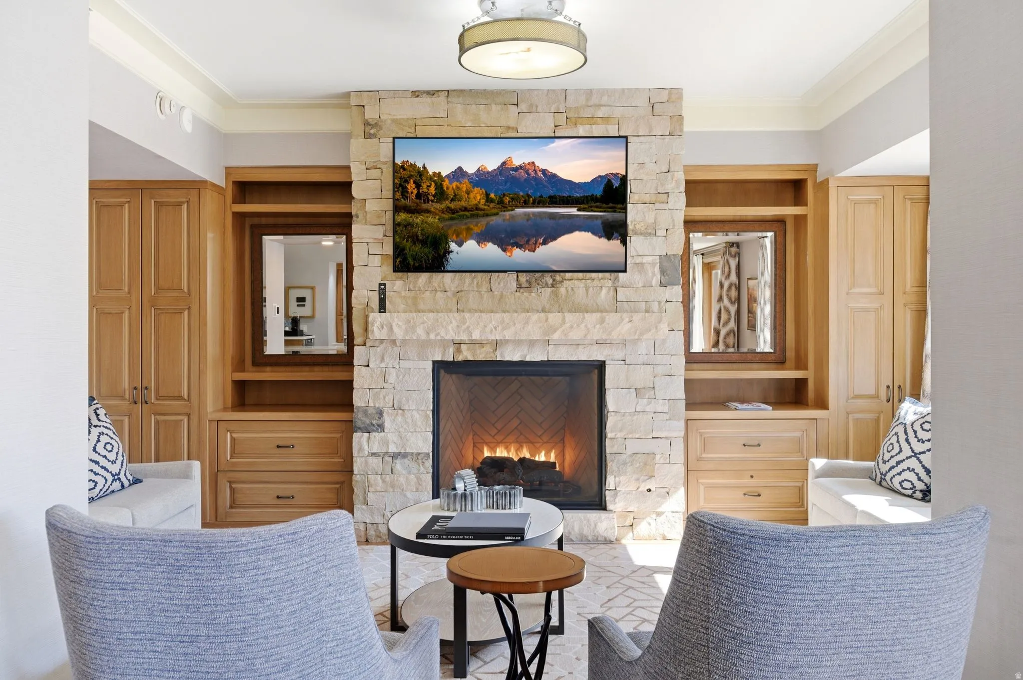 Stone-clad fireplace feature with an integrated television and built-in wood cabinetry