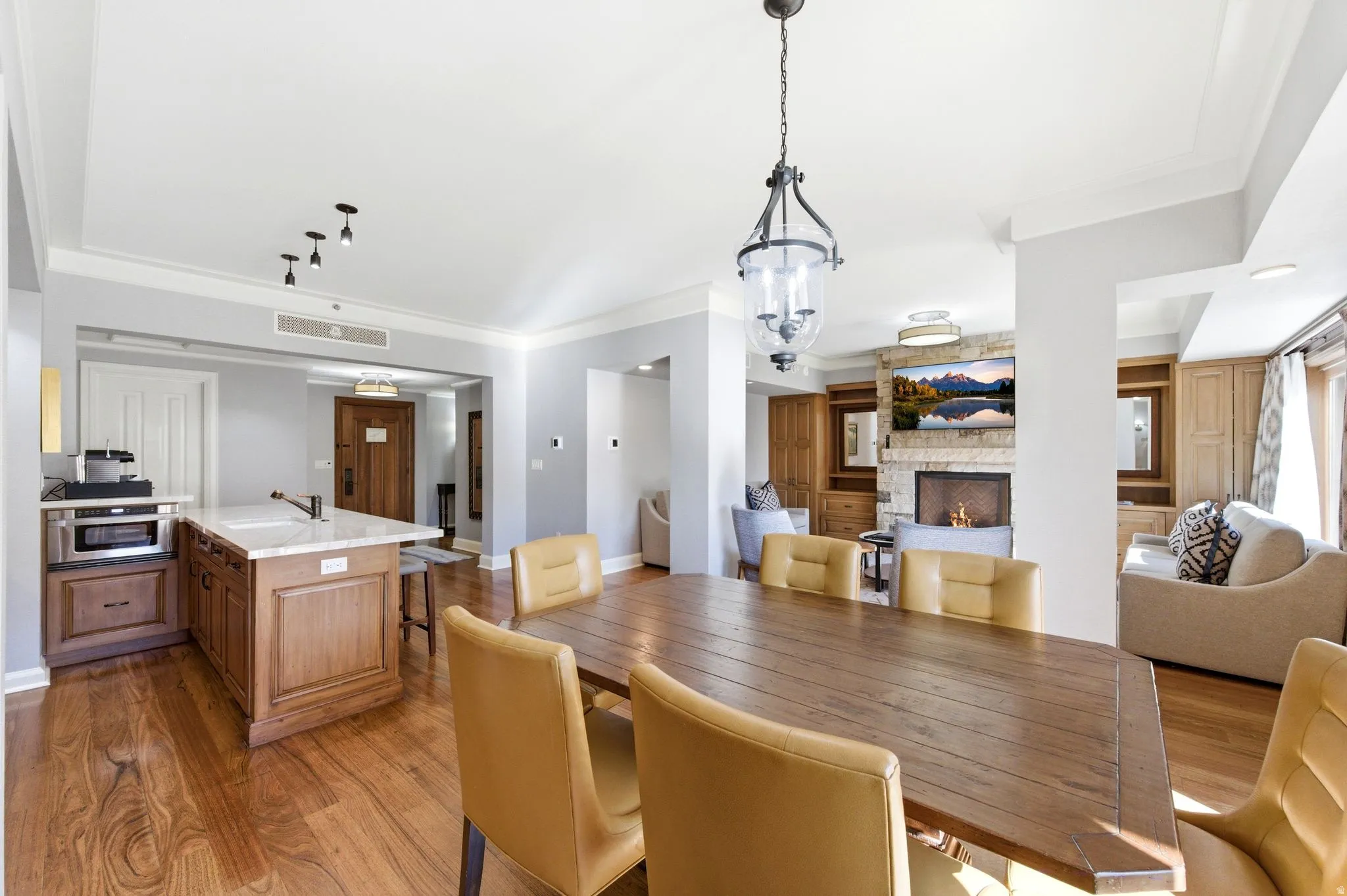 Open-concept dining area featuring wood-finish flooring and a central chandelier
