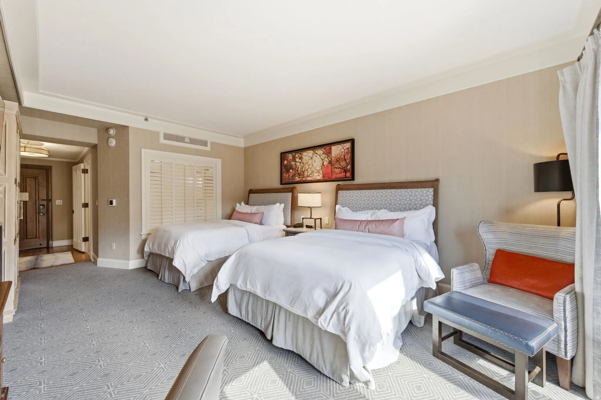 Carpeted room featuring two beds with patterned headboards and recessed lighting