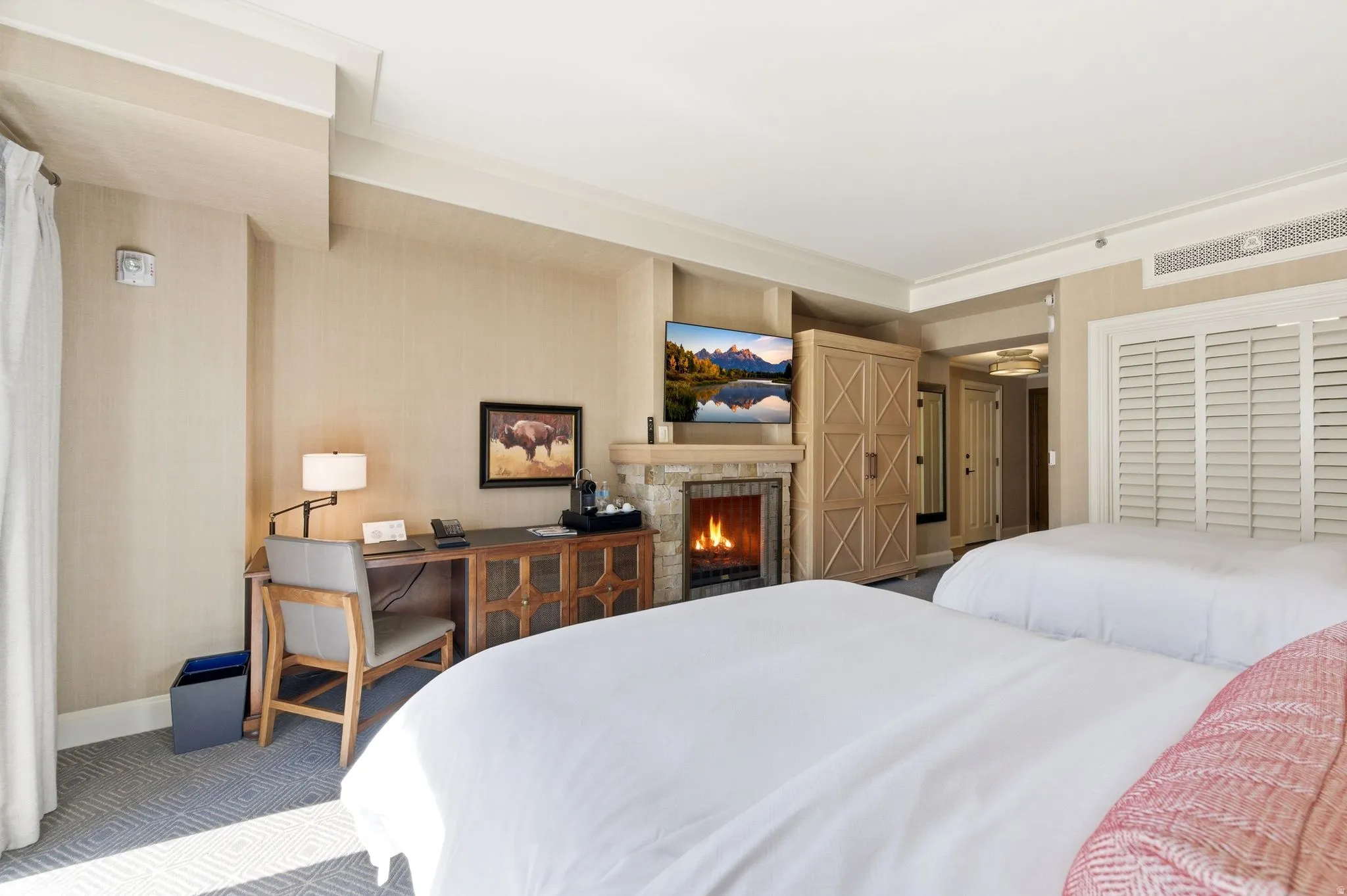 Interior space featuring a stone-clad fireplace with a mounted television above