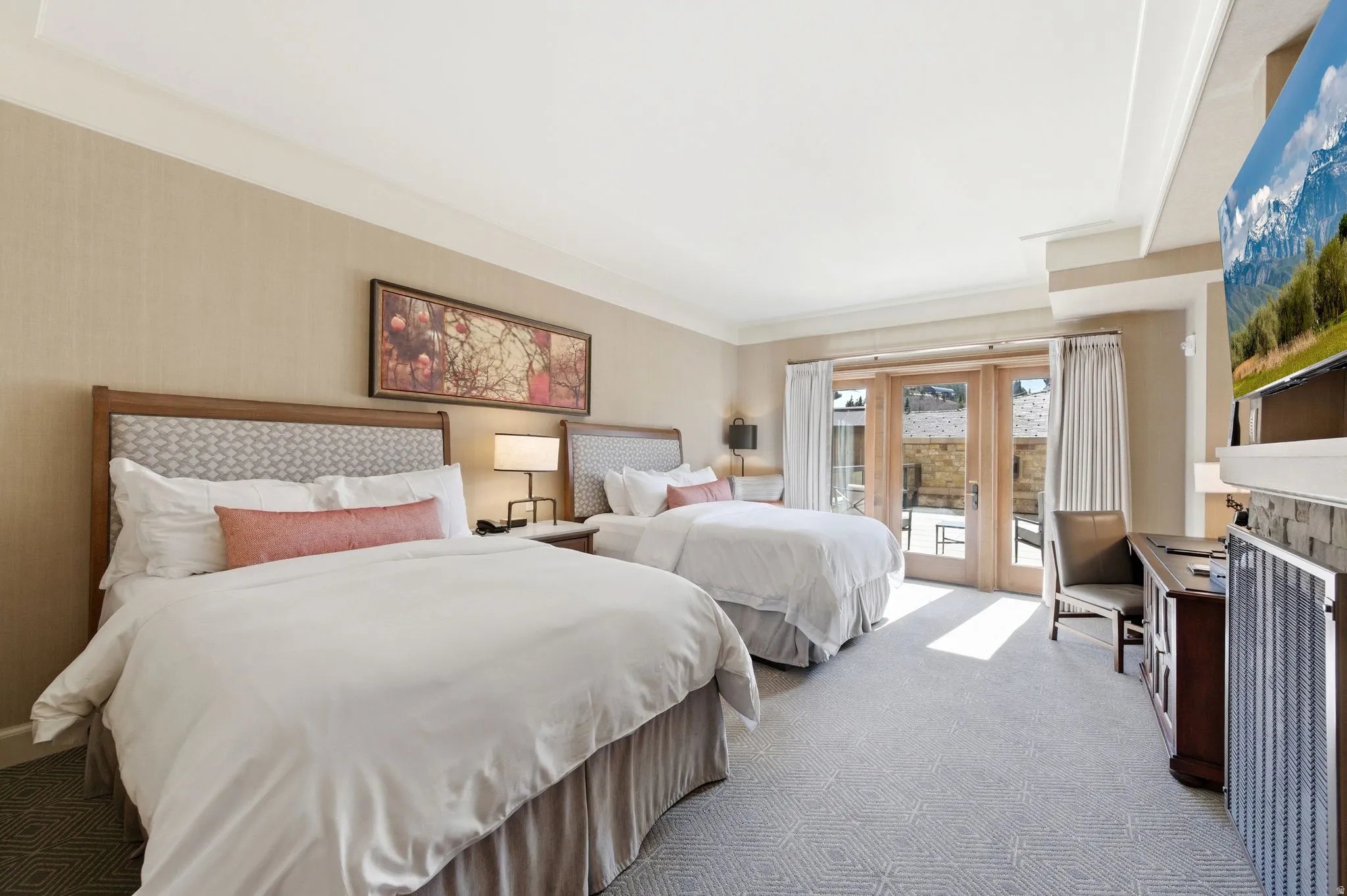 Spacious room featuring two beds with patterned headboards, textured wall covering, and crown molding