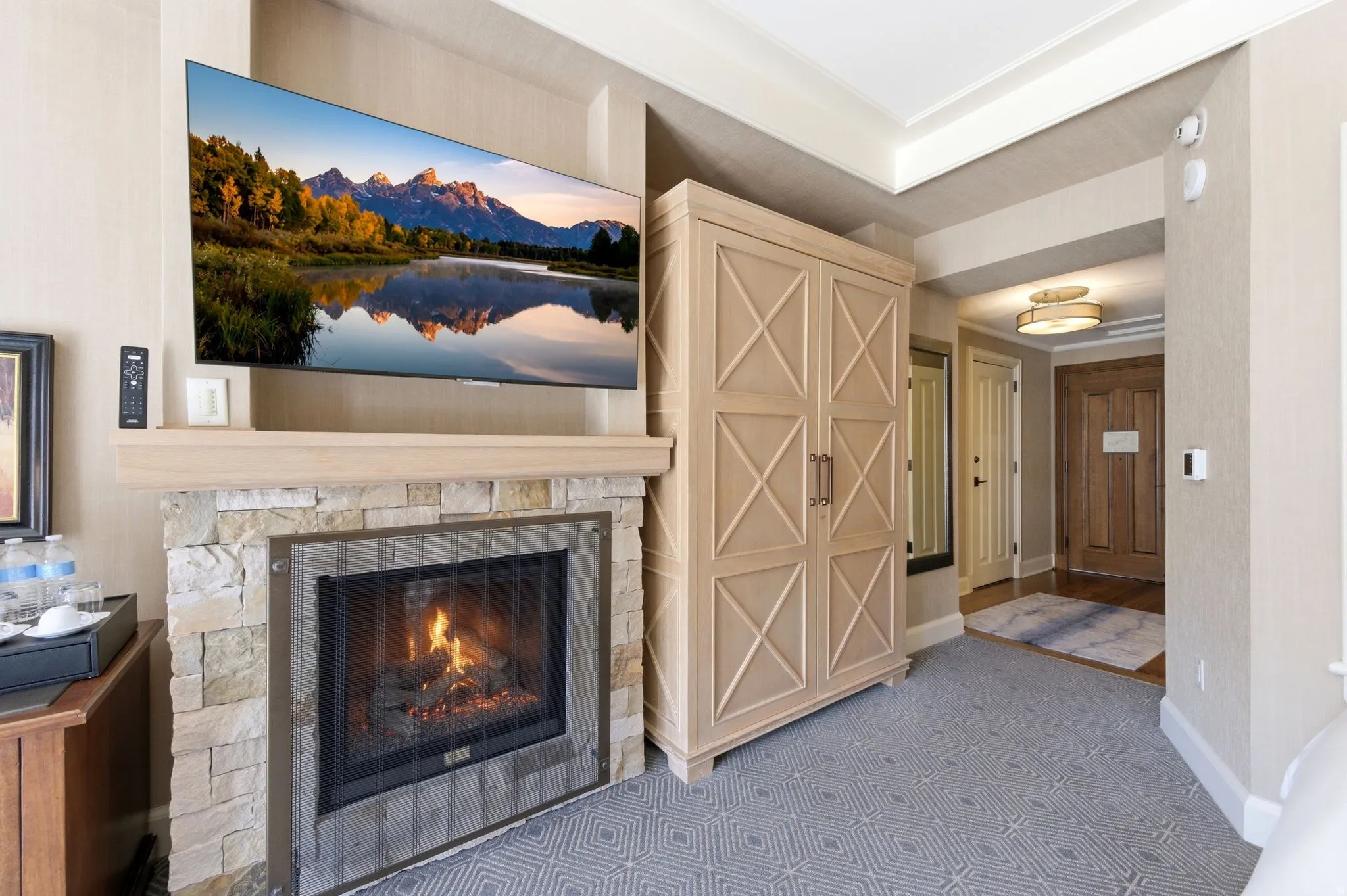 Stone-faced fireplace with a substantial hearth and mantel, complemented by a large wall-mounted television
