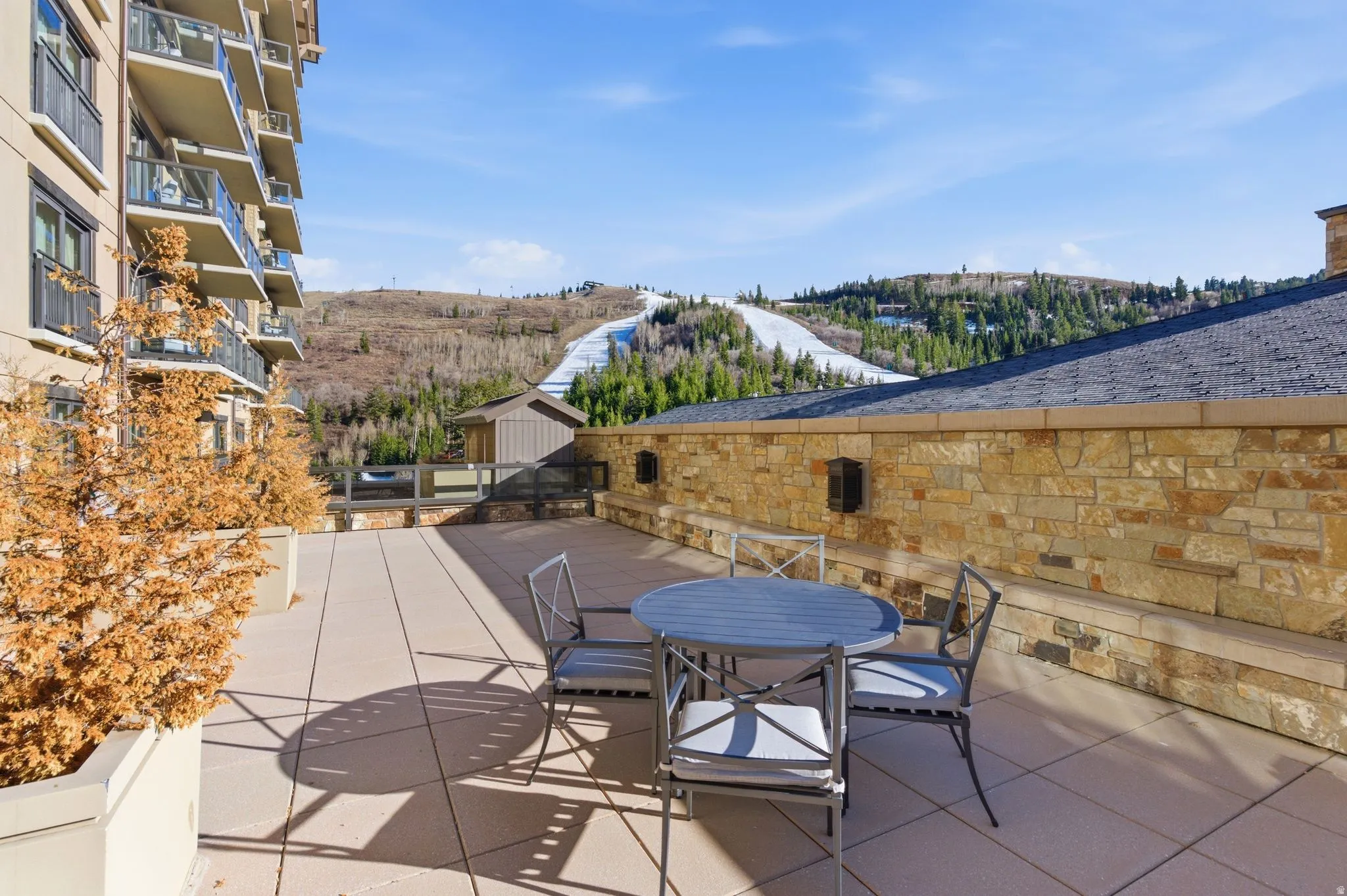 Spacious outdoor patio with stone wall surround and mountain scenery