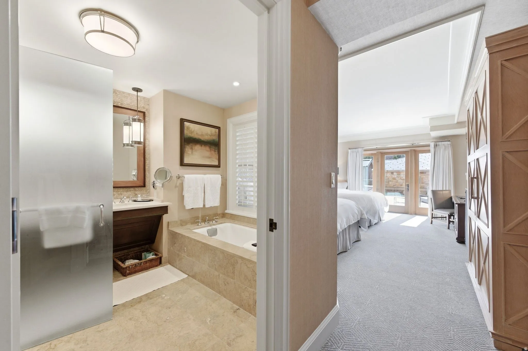 Contemporary bathroom featuring a frosted glass door, built-in soaking tub with stone surround, and a wood-finish vanity with an undermount sink