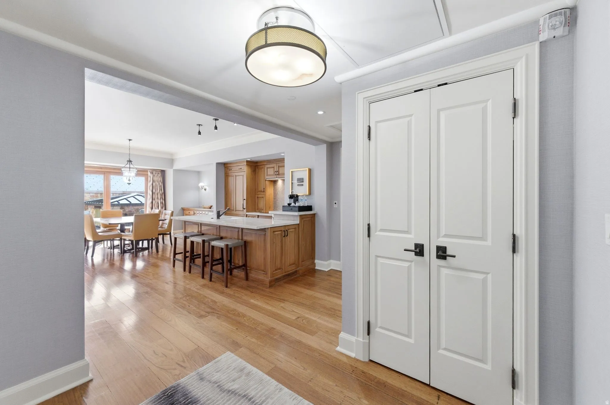 Hardwood flooring extending into an open-concept living space with a kitchen island and dining area