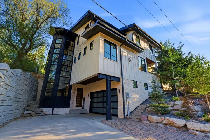 Contemporary multi-level residence featuring a striking glass-encased exterior staircase