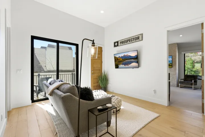Living area featuring light wood-finish flooring, white walls, and recessed lighting