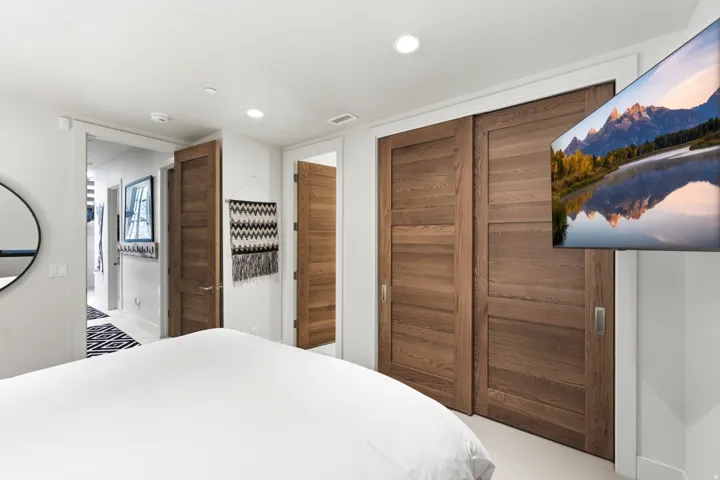Wood-finish sliding closet doors with recessed pulls and flush paneling